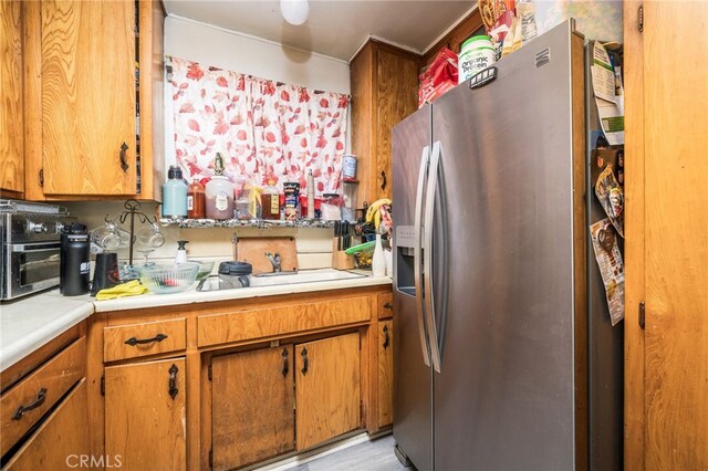 kitchen featuring stainless steel fridge and light hardwood / wood-style flooring