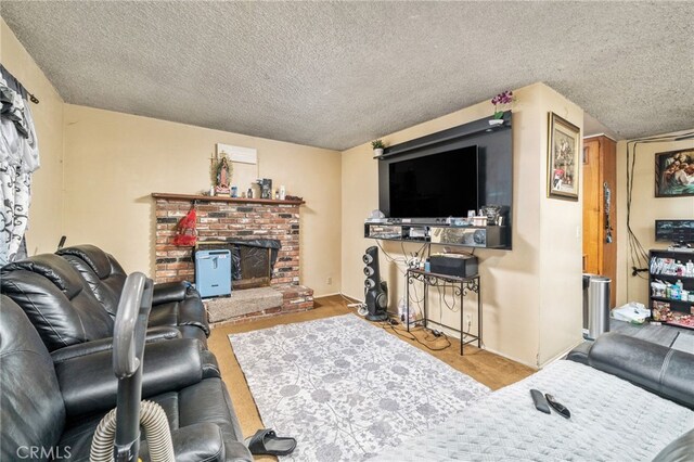 living room with a textured ceiling, a fireplace, and light wood-type flooring