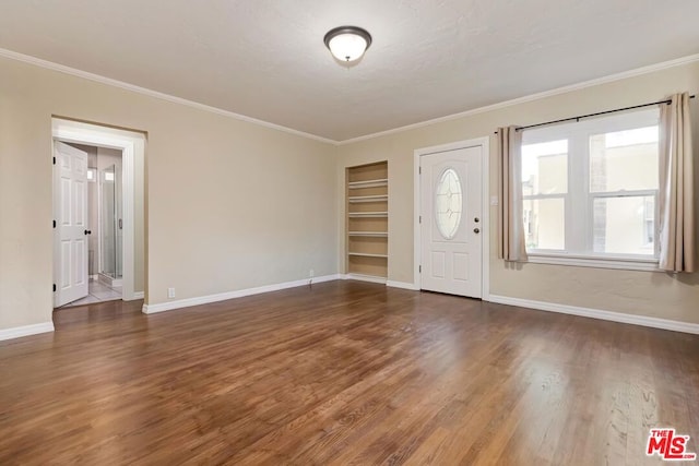 foyer entrance with ornamental molding and dark wood-type flooring