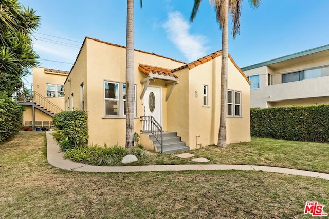 mediterranean / spanish-style home with a front yard