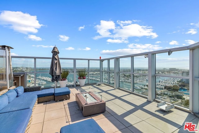 view of patio with a balcony and an outdoor fire pit