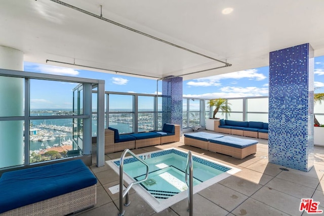 view of pool featuring a water view, an outdoor living space, and an indoor in ground hot tub