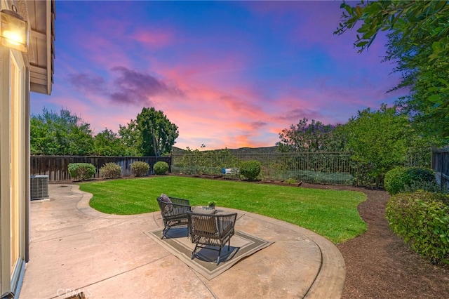 patio terrace at dusk with central AC unit and a lawn