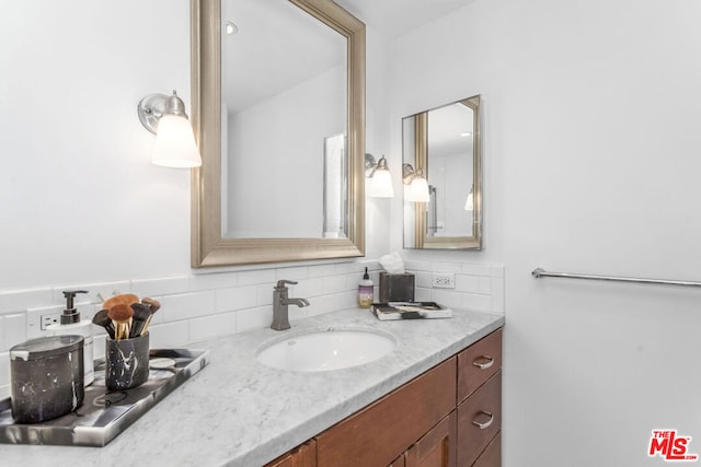 bathroom featuring vanity and tasteful backsplash