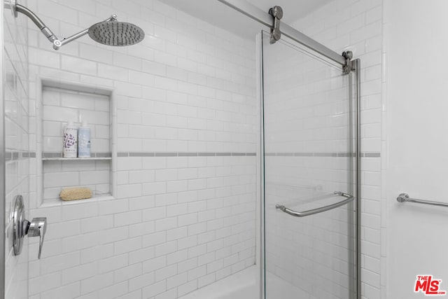 bathroom featuring a shower with shower door