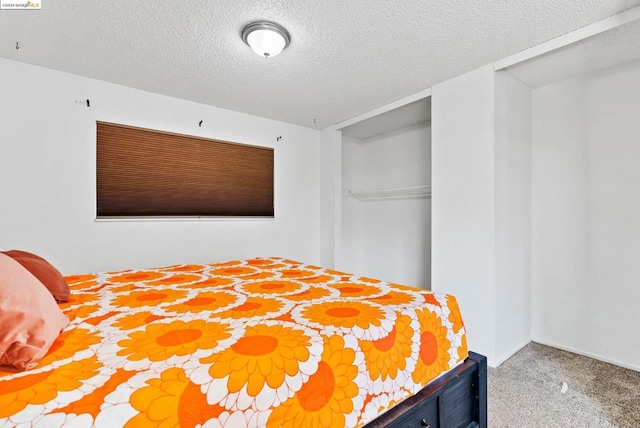 carpeted bedroom with a closet and a textured ceiling