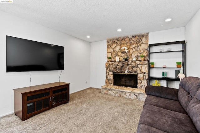 carpeted living room featuring a fireplace and a textured ceiling