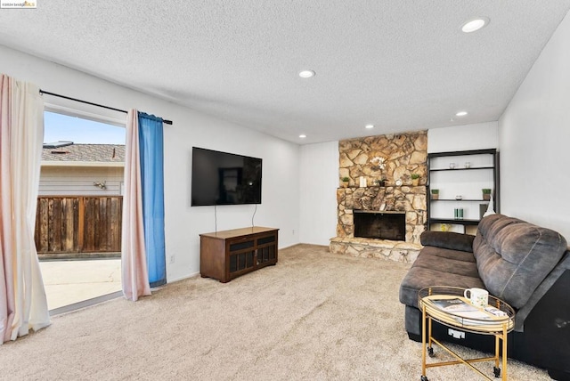 living room featuring a fireplace, a textured ceiling, and carpet floors