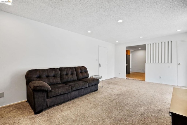 carpeted living room featuring a textured ceiling