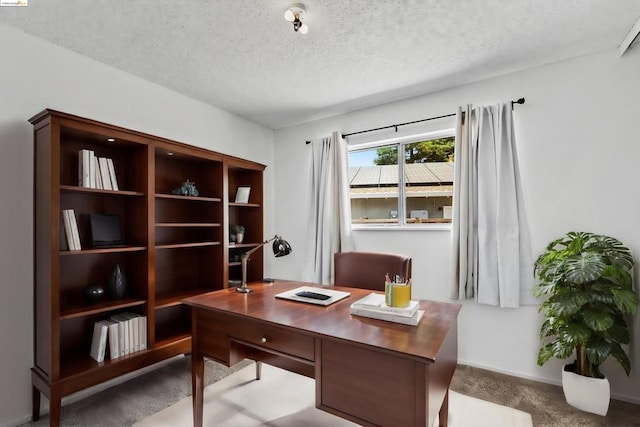 home office featuring a textured ceiling and carpet floors