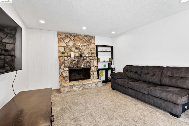 living room with a fireplace, a textured ceiling, and carpet flooring