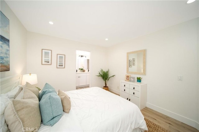 bedroom with light hardwood / wood-style floors and connected bathroom