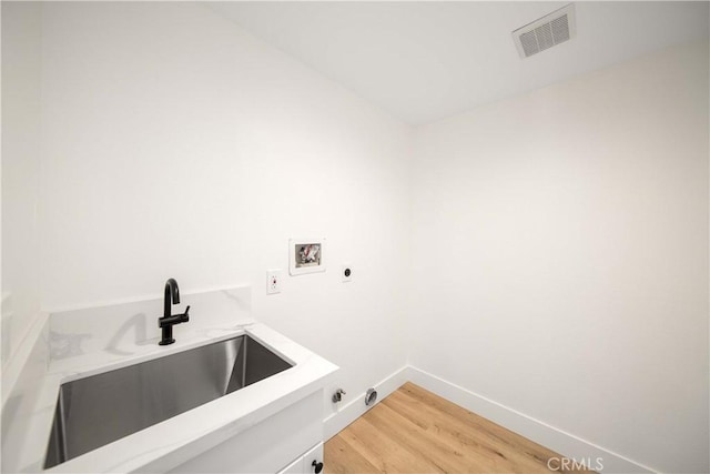 laundry room with wood-type flooring, washer hookup, electric dryer hookup, and sink