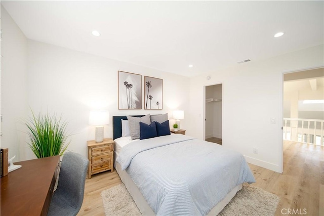 bedroom featuring light hardwood / wood-style floors, a spacious closet, and a closet