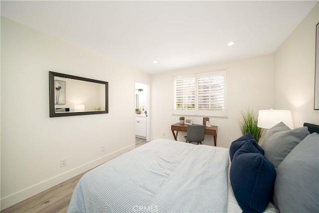 bedroom featuring ensuite bathroom and light hardwood / wood-style flooring