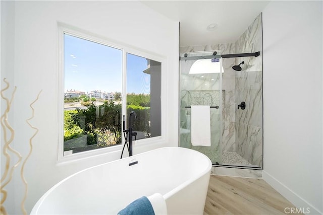 bathroom with hardwood / wood-style floors, plenty of natural light, and plus walk in shower