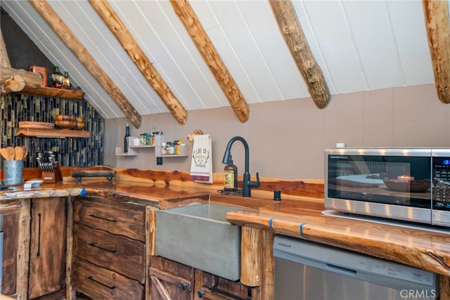 kitchen featuring sink, lofted ceiling with beams, and appliances with stainless steel finishes