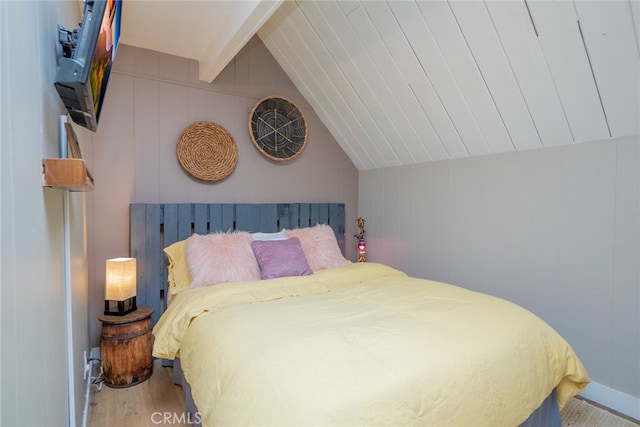 bedroom featuring wood-type flooring and vaulted ceiling with beams