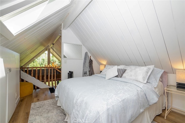 bedroom with lofted ceiling with skylight and light wood-type flooring