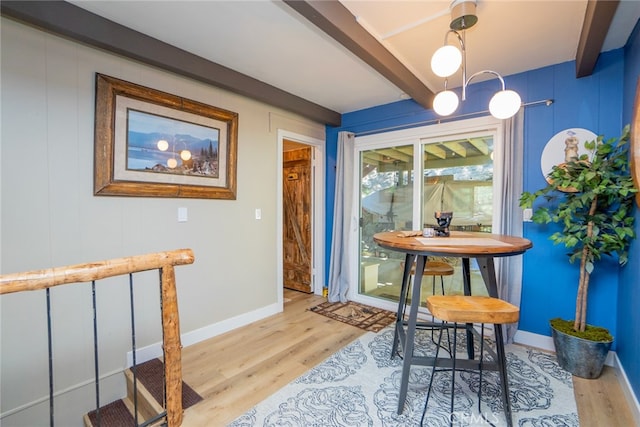 dining space featuring beamed ceiling and light hardwood / wood-style flooring