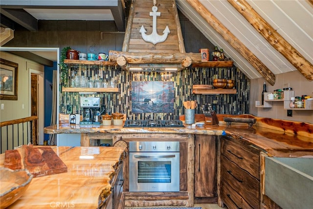 interior space featuring black gas stovetop, vaulted ceiling with beams, stainless steel oven, and wood counters