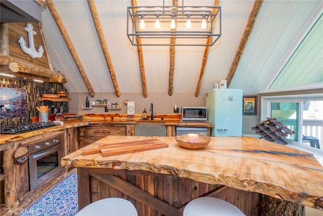 kitchen featuring stainless steel appliances, sink, water heater, and vaulted ceiling with beams