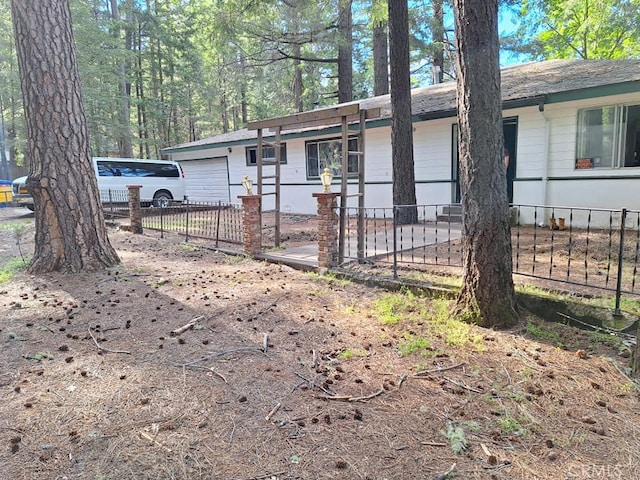 ranch-style house featuring an attached garage and fence