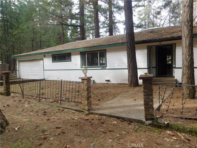 ranch-style house with a garage and fence