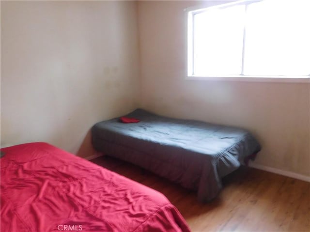 bedroom with baseboards and wood finished floors