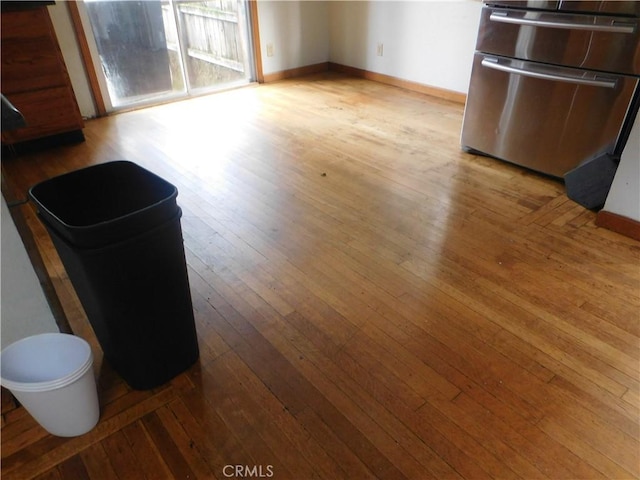 interior space featuring light wood-style floors, baseboards, and fridge