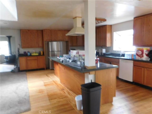 kitchen featuring extractor fan, a center island, dishwasher, brown cabinetry, and dark countertops