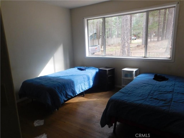 bedroom featuring multiple windows and wood finished floors