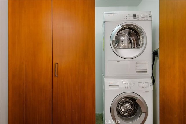 clothes washing area with stacked washer and clothes dryer