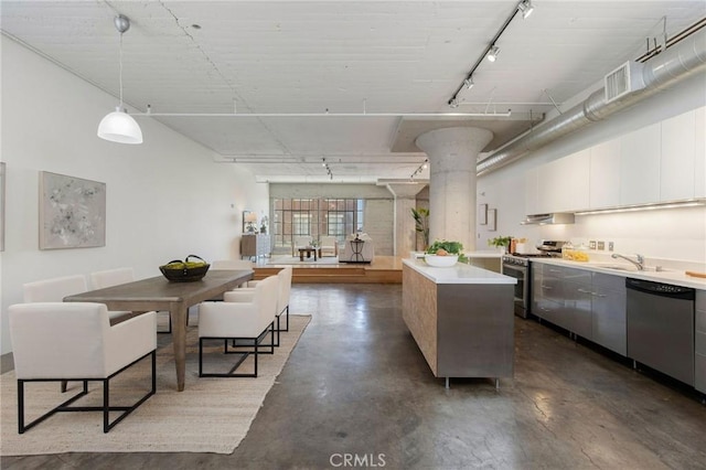 kitchen with white cabinetry, pendant lighting, track lighting, a kitchen island, and appliances with stainless steel finishes