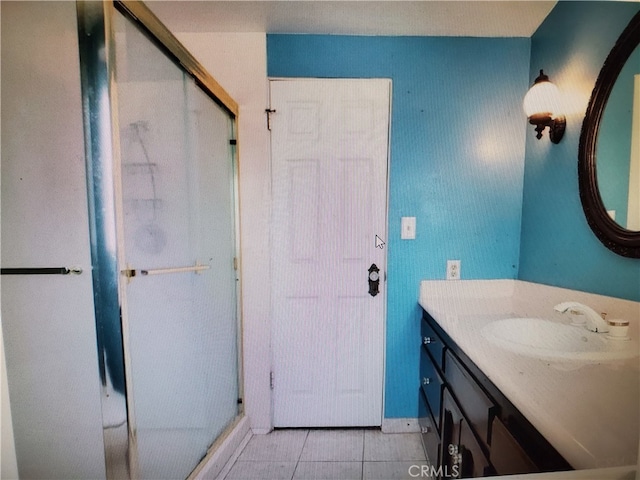 bathroom featuring vanity, tile patterned floors, and a shower with door