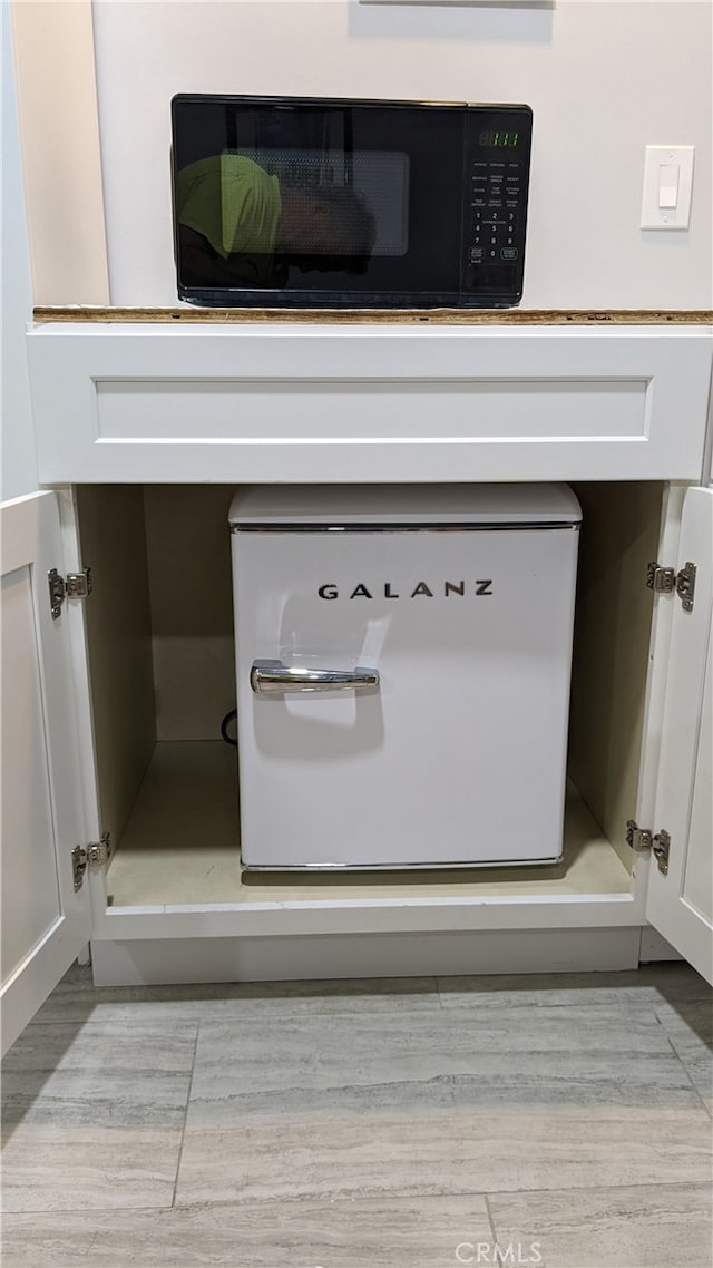 interior details with white cabinetry and light wood-type flooring