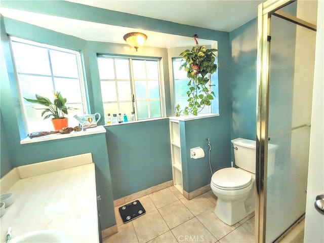 bathroom featuring toilet, a shower with shower door, vanity, and tile patterned flooring