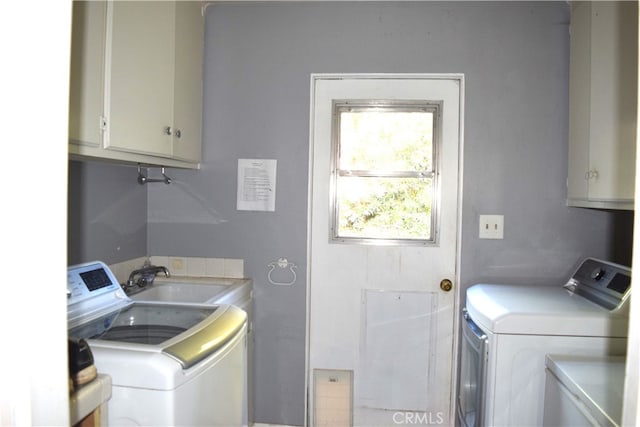 laundry room featuring cabinets, sink, and washer and clothes dryer