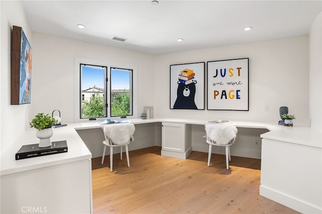 home office featuring built in desk and light hardwood / wood-style floors