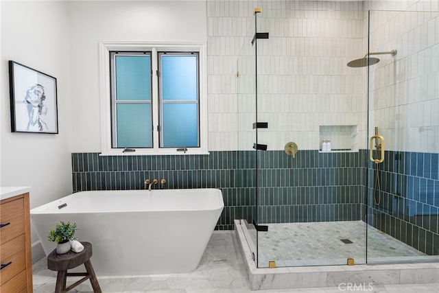 bathroom with vanity, tile walls, and independent shower and bath