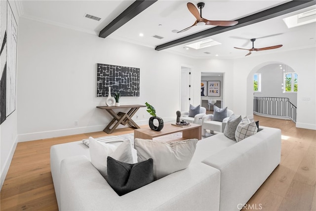 living room with beam ceiling, crown molding, and light hardwood / wood-style floors