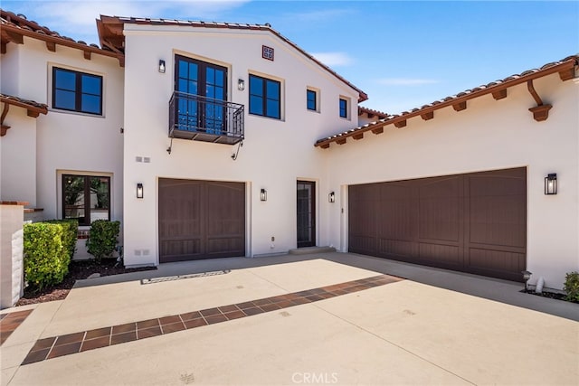 mediterranean / spanish-style house featuring a garage and a balcony