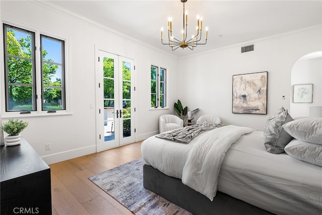 bedroom with access to outside, light hardwood / wood-style flooring, an inviting chandelier, and ornamental molding