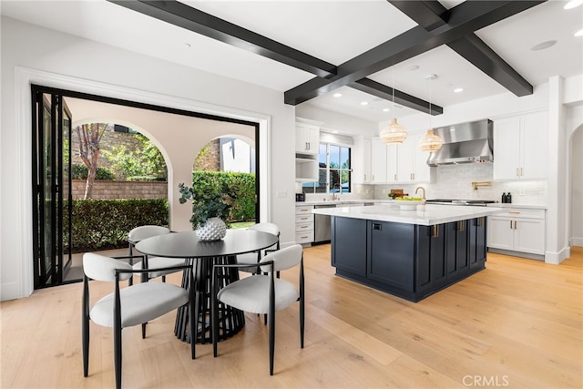 dining area with beam ceiling and light hardwood / wood-style floors