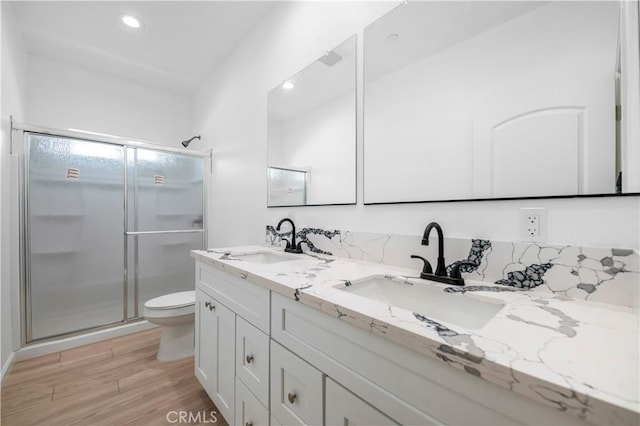 bathroom featuring hardwood / wood-style flooring, vanity, toilet, and walk in shower