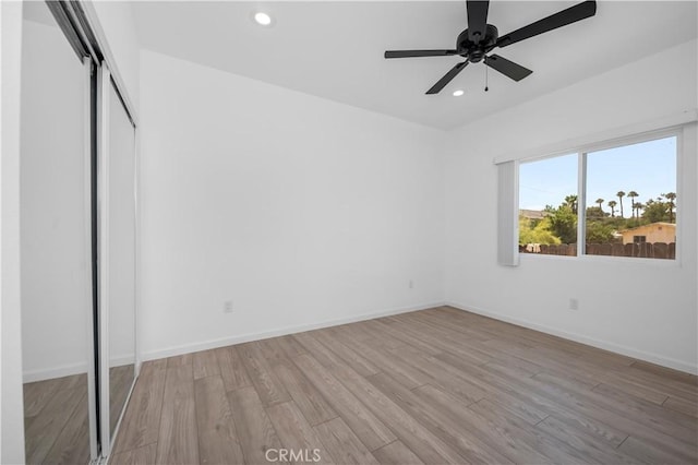 unfurnished bedroom featuring ceiling fan, light wood-type flooring, and a closet