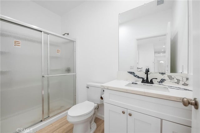 bathroom featuring vanity, hardwood / wood-style flooring, toilet, and an enclosed shower