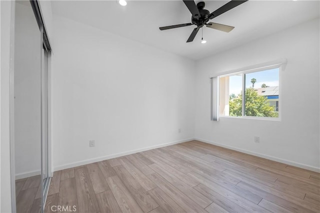 unfurnished bedroom featuring ceiling fan, light hardwood / wood-style floors, and a closet