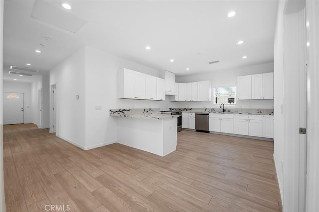 kitchen featuring kitchen peninsula, light hardwood / wood-style flooring, white cabinets, and stainless steel appliances