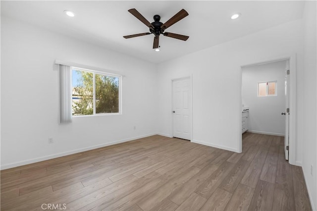 unfurnished bedroom featuring connected bathroom, ceiling fan, a closet, and light wood-type flooring